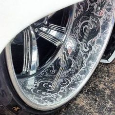 the wheels and rims of a white car are painted with intricate designs on it