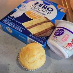 a cupcake, yogurt and some other items on a counter top next to a box of zero sugar