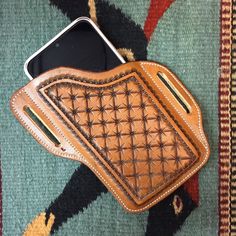 a cell phone in a leather case on a rug