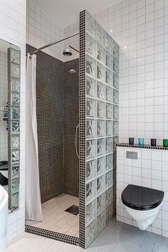 a bathroom with a black and white toilet next to a walk in shower