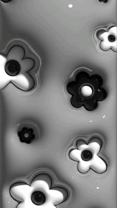 some black and white flowers are in the water with one flower on it's side