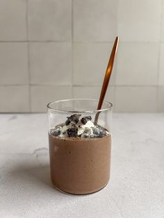 a glass with some food in it sitting on a counter next to a tile wall