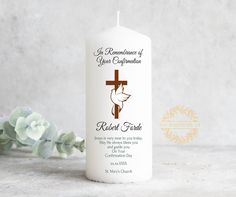 a white candle with a cross on it