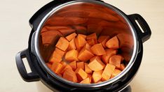 a large pot filled with chopped carrots on top of a table