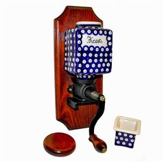 an old fashioned wooden phone with blue and white polka dots on the cover, next to it's holder