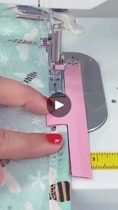 someone is using a sewing machine to sew something on the fabric with their thumbnails