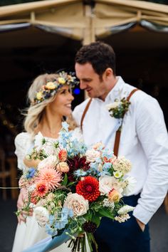 a bride and groom holding a bouquet of flowers