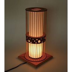 a lamp that is sitting on top of a wooden stand with a cord attached to it