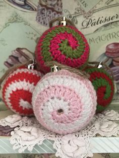 three crocheted ornaments sitting on top of a doily