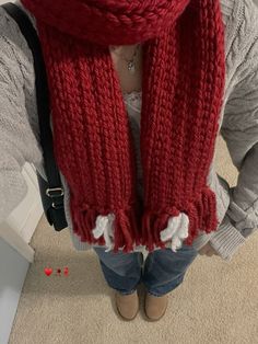 a woman is wearing a red scarf with white pom - poms on it