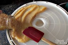 a plastic container filled with food and a red spatula on top of the lid