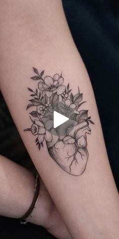 a woman's arm with a heart and flowers on it