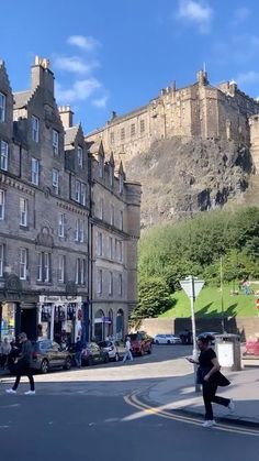 people are walking on the street in front of some old buildings and castle like structures