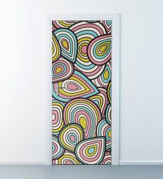 an open door with a colorful pattern on the front and side panels, in a white room