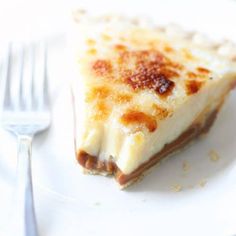 a slice of cheese pizza on a white plate with a fork and knife next to it