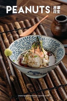 a bowl filled with rice covered in sauce and garnished with green onions next to chopsticks