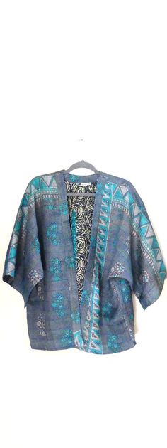 Reversible silk kantha stitch kimono jacket. It is made from tow layer of silk put together then handstitched and is lightweight yet warm and also cool when it's hot! Great for traveling with as can be dressed up or dressed down and looks great with jeans or equally over a dress!  This piece is unique and has wide sleeves and will fit a size 10 to 16 UK size.  100% silk Length: 25" - longer version Blue Bohemian Kimono With Natural Dye, Bohemian Blue Kimono With Natural Dye, Bohemian Kimono With Kimono Sleeves For Festive Occasions, Fall Silk Kimono With Open Front, Blue Bohemian Outerwear For Festive Occasions, Fall Silk Open Front Kimono, Bohemian Silk Kimono For Festive Occasions, Traditional One-size Kimono With Kimono Sleeves, Festive Kimono With Kimono Sleeves