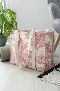 a pink toiler bag sitting on the floor next to a potted plant