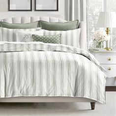 a bed with green and white striped comforter