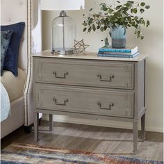 a nightstand with two drawers and a lamp on top