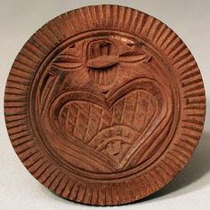 a small wooden plate with a heart and cross on the front, made out of wood