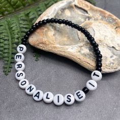 A super cute plain black name bracelet with your choice of wording and size! Personalise it with your name, your child's name, an inspirational word, your team name, a pet name, a nickname, or anything else you can think of eg Best Nanny, Bridesmaid, or an anniversary date or birth date. Why not get one for yourself and one for your bestie?The custom made bracelet has 4mm glass seed beads and flat white acrylic letter beads, which are 7mm diameter. The seed beads are plain black, meaning you can Black Beaded Bracelet With Letter Print As Gift, Black Beaded Bracelets With Letter Print As Gift, Personalized Black Beaded Bracelets, Adjustable, Novelty Black Friendship Bracelets, Black Wristband With Round Beads For Friendship, Black Round Beads Wristband For Friendship, Casual Black Stretch Bracelet With Letter Beads, Black Inspirational Friendship Bracelets, Inspirational Black Friendship Bracelets