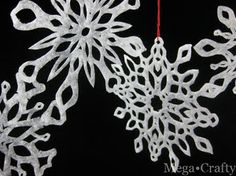 two snowflakes hanging from a red string