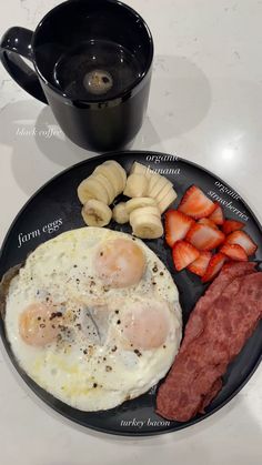 an english breakfast with bacon, eggs and strawberries on a plate next to a coffee cup