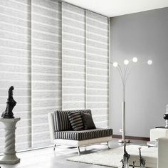 a modern living room with grey walls and white furniture in front of the window coverings