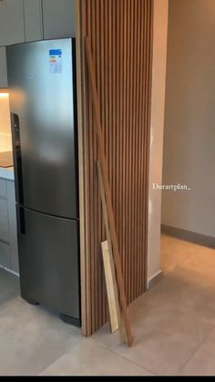 a modern kitchen with stainless steel refrigerator and wood slats