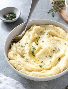 a bowl filled with mashed potatoes and garnished with parsley on the side