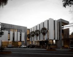 a building with palm trees in front of it and cars parked on the street outside