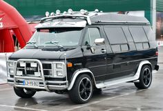 an old black van parked in a parking lot