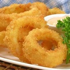 fried onion rings on a plate with dipping sauce