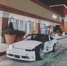 a white car parked in front of a building