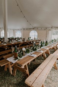 an outdoor tent with tables and benches