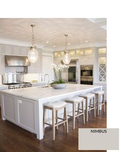 a large kitchen with white cabinets and marble counter tops, an island with four stools