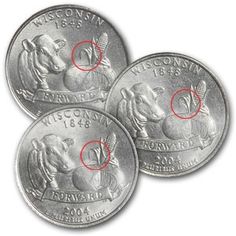 three silver coins with red marks on the front and back of one coin, which is smaller than the other