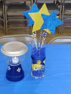 a blue table topped with a vase filled with stars