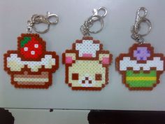 four pixel keychains are hanging on a refrigerator freezer in the shape of cartoon characters