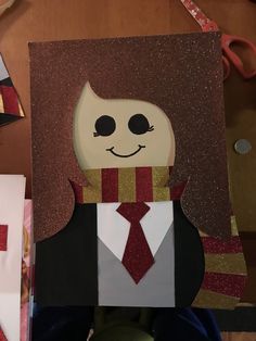 paper cut out of a man wearing a suit and tie, with scissors in the background