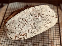 a loaf of bread sitting on top of a cooling rack covered in frosting and flowers