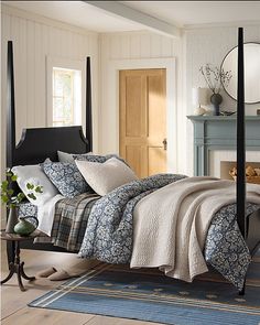 a bed sitting next to a fireplace in a bedroom