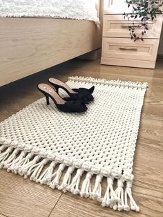 a pair of high heeled shoes sitting on top of a white rug next to a bed