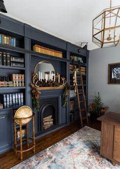 a living room with bookshelves, fireplace and christmas decorations on the mantel