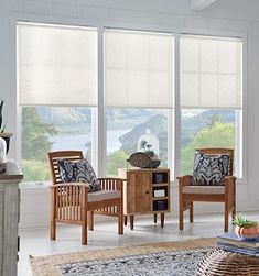 a living room filled with furniture and large windows covered in blind shades over the windows