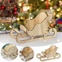 a wooden toy sleigh with christmas decorations and pine cones on the table next to it