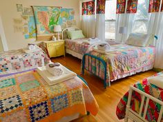 two beds in a room with colorful quilts on them