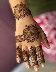 a woman's hand with henna tattoos on it