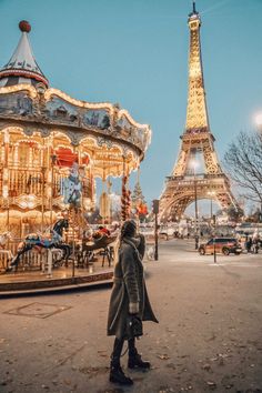 a woman standing in front of the eiffel tower with a merry go round